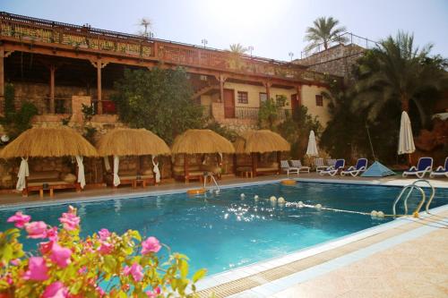 沙姆沙伊赫纳马蓝色度假村的一个带椅子和遮阳伞的游泳池和一座建筑