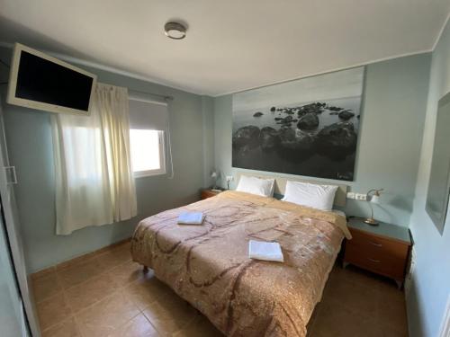 坎德拉里亚坎德拉里亚之家酒店的卧室配有一张大床,墙上配有电视