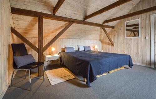 格林斯泰兹Gorgeous Home In Grindsted With Wifi的一间卧室,卧室内配有一张床和一把椅子
