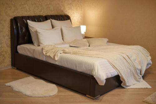 戈梅利PaulMarie Apartments on Prs. Lenina, 51的一张大床,配有黑色框架和白色枕头