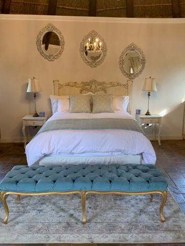 比勒陀利亚La-Perna Guesthouse and Venue的一间卧室配有一张大床和蓝色长凳