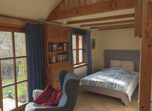 策勒Kastanienhof Alvern的一间卧室配有一张床、一把椅子和窗户。