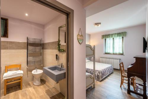 塞斯托拉Locanda San Giorgio的一间带水槽的浴室和一间带一张床的卧室