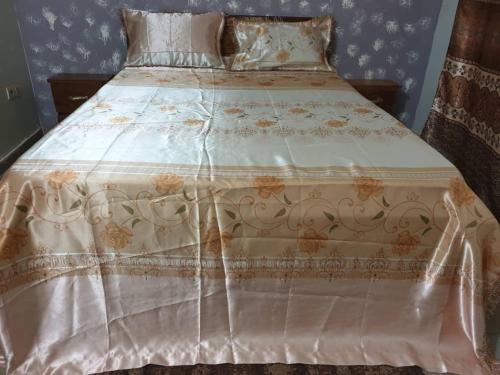 巴马科IMMEUBLE KCF的一张带白色床单的床,上面有鲜花