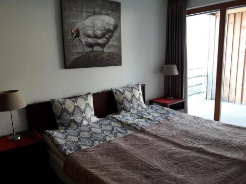 安特特泽Holiday apartment #103 on Walensee的卧室配有一张床,墙上挂着一幅火鸡的照片