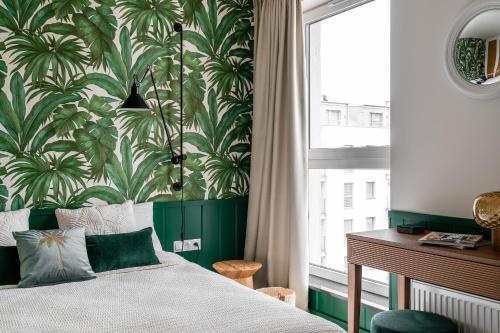 格但斯克Apartament Ap175的一间卧室配有一张带绿色和白色壁纸的床