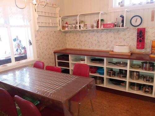 埃基斯蒂尔Húsey Hostel & Horsefarm的一间带桌子和红色椅子的用餐室