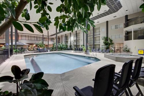 坎卢普斯Coast Kamloops Hotel & Conference Centre的一座带椅子的建筑和一座大楼内的游泳池