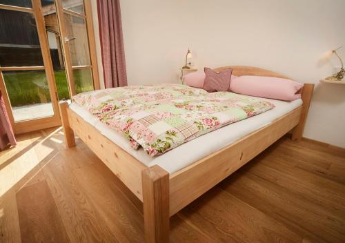 施利尔塞Ferienwohnung Glaserhäusl Seeblick的一间卧室配有一张木床,床上有毯子