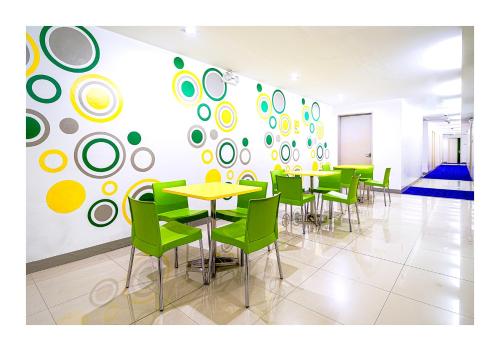 马尼拉Go Hotels Ortigas Center的用餐室配有桌子和绿色椅子