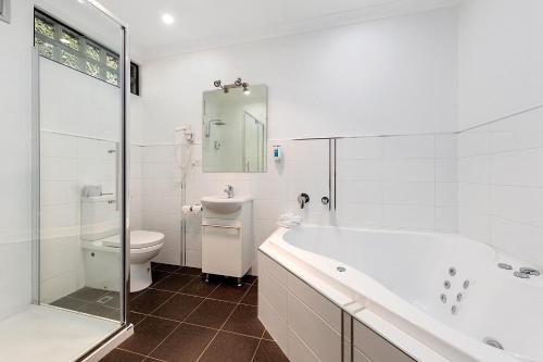 朗塞斯顿科摩多里根酒店的带浴缸、卫生间和盥洗盆的浴室