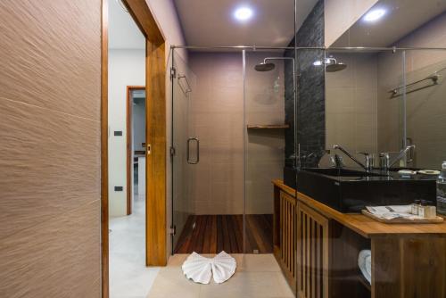新孔Zee Luxury Boutique Hotel的一间带水槽和玻璃淋浴的浴室
