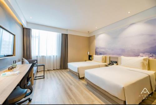 南京Atour Hotel Maqun Nanjing的酒店客房配有两张床和一张书桌