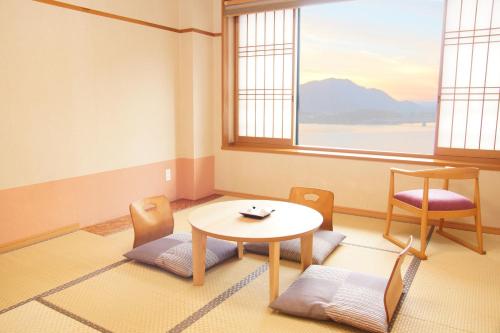 富士河口湖Asafuji温泉酒店的客房设有桌椅和窗户。