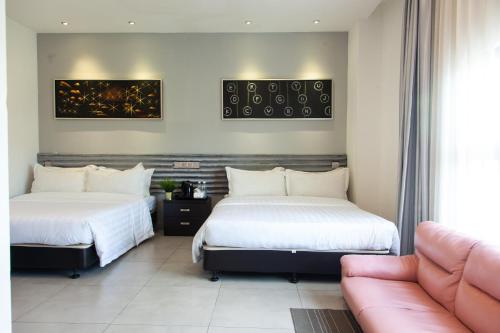 吉隆坡M Design Hotel @ Shamelin Perkasa的一张沙发的酒店客房内的两张床