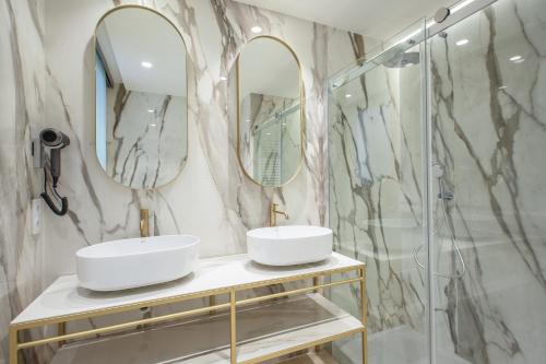 卡拉圣维森特莫林斯酒店的浴室设有2个水槽和2面镜子