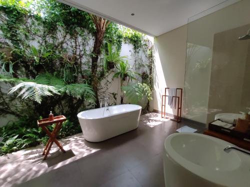 乌布Santun Luxury Private Villas-CHSE CERTIFIED的带浴缸、水槽和树的浴室