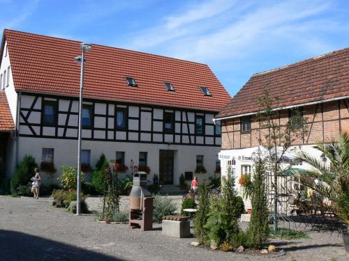 Daasdorf am BergePension Schütze的两栋建筑,拥有红色屋顶和种有植物的庭院
