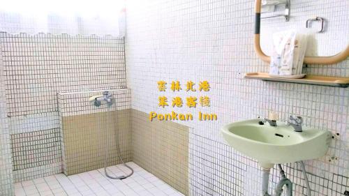 北港镇笨港客栈的一间带水槽和白色瓷砖墙的浴室