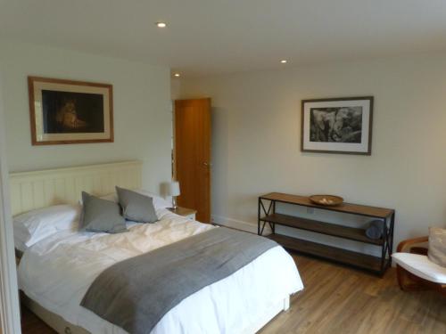 格拉斯顿伯里The Woodshed - A newly built, 2 bedroom, cottage near Glastonbury的一间卧室配有一张大床和一张桌子