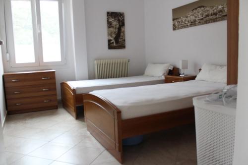 内亚卡瓦里Pares Comfort Apartment的一间卧室设有两张床和窗户。