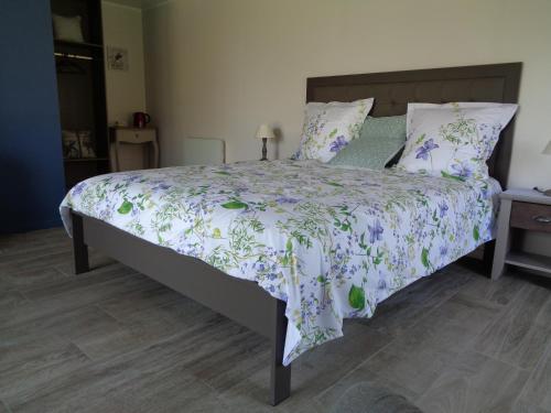 Vitry-aux-Logesla Monlassière的一间卧室配有一张带紫色和绿色棉被的床