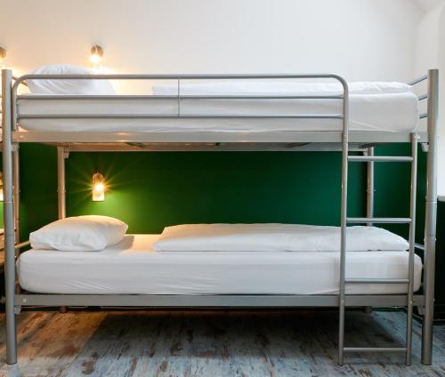 柏林博尔豪斯柏林旅舍的绿色墙壁客房中的两张双层床