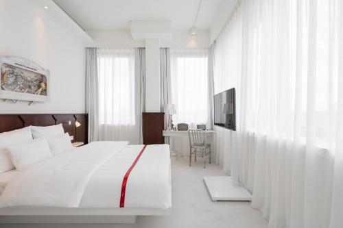 杜塞尔多夫Ruby Leni Hotel Dusseldorf的白色卧室配有床和书桌