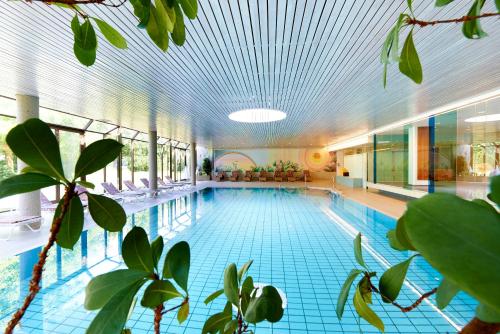 沃尔特湖畔佩莎赫Parkhotel Pörtschach - Das Hotelresort mit Insellage am Wörthersee的一个带天花板的大型游泳池