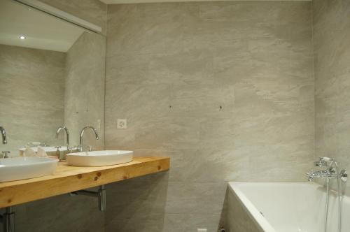格林德尔瓦尔德Chalet Obelix的浴室设有2个水槽、浴缸和镜子