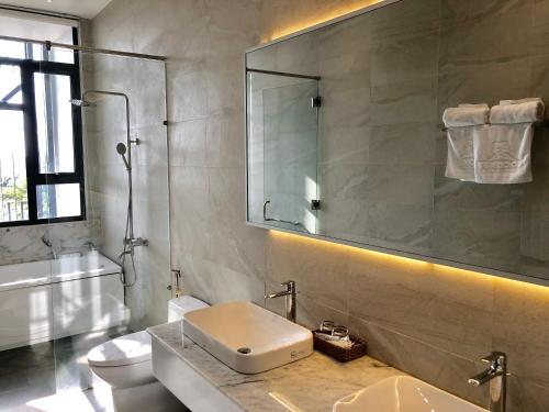 绥和市Coconut Hotel Phú Yên的一间带水槽、卫生间和镜子的浴室