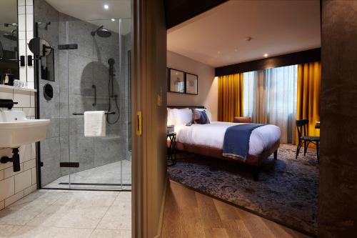 曼彻斯特voco Manchester - City Centre, an IHG Hotel的酒店客房配有一张床和淋浴