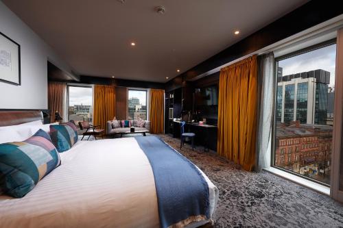 曼彻斯特voco Manchester - City Centre, an IHG Hotel的酒店客房设有一张大床和大窗户