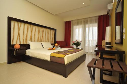 波塞蒂Xenios Possidi Paradise Hotel的一间卧室配有一张大床、一张桌子和一张书桌