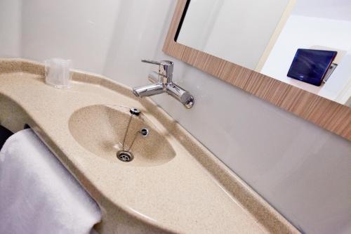 特里尼亚克普瑞米尔圣纳扎尔特里纳克经典酒店的一间带水槽和镜子的浴室