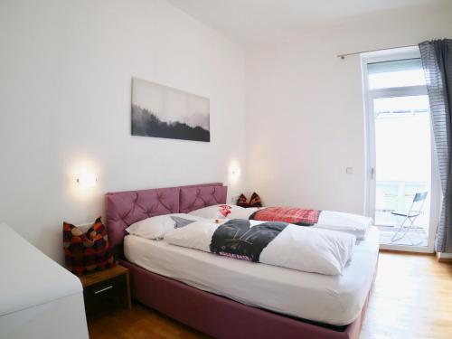 因斯布鲁克Suite Mutters的卧室内的一张带粉红色床头板的床