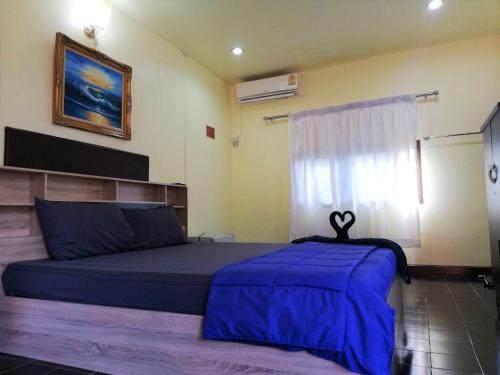 攀牙府Phurafa Resort的一间卧室配有一张带蓝色床单的床和一扇窗户。