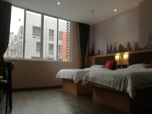 柳州尚客优酒店广西柳州沃尔玛金福第店的一间卧室设有两张床和大窗户