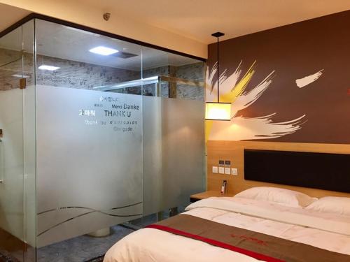 泉州尚客优酒店福建泉州丰泽区东海大街店的一间卧室设有一张床和玻璃墙
