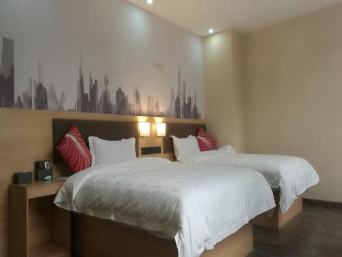 柳州尚客优酒店广西柳州沃尔玛金福第店的卧室内的两张床,墙上挂有城市壁画