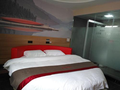 泰州尚客优酒店江苏泰州客运西站建行店的一间卧室配有一张大床和红色床头板
