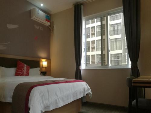 柳州尚客优酒店广西柳州沃尔玛金福第店的酒店客房设有床和窗户。