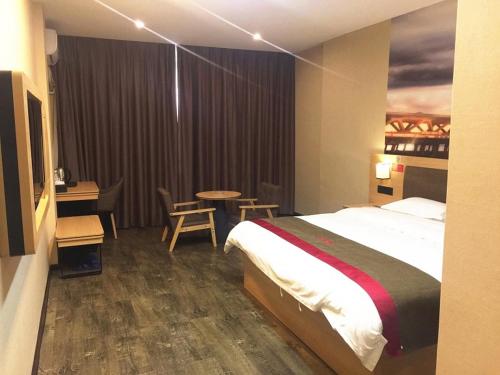 柳州尚客优酒店广西柳州鹿寨县广场店的酒店客房带一张床、一张桌子和椅子
