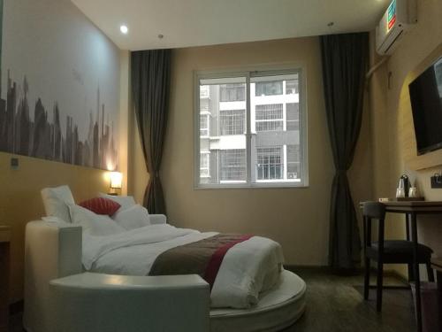 柳州尚客优酒店广西柳州沃尔玛金福第店的一间卧室设有一张大床和一个窗户。