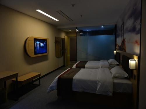 绵阳尚客优酒店四川绵阳御中路机场店的卧室配有一张床,墙上配有电视。