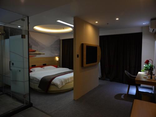 绵阳尚客优酒店四川绵阳御中路机场店的一间酒店客房,配有一张床和一台电视