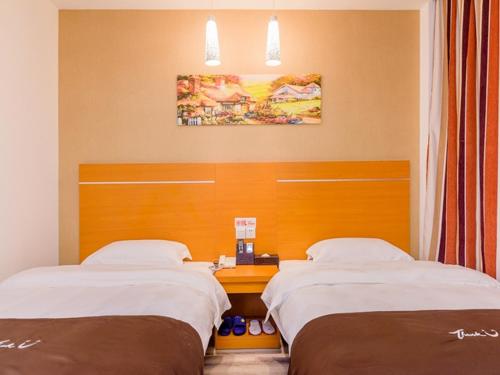 广州尚客优酒店广东广州新白云机场店的一张位于酒店客房内的两张床,配有书桌