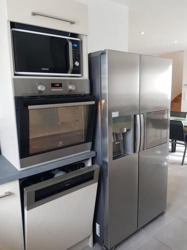 滨海拉特朗什LES EMBRUNS的厨房配有微波炉和冰箱。
