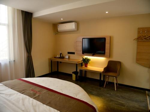 徐州尚客优酒店江苏徐州鼓楼区大黄山店的酒店客房配有一张床、一张书桌和一台电视。