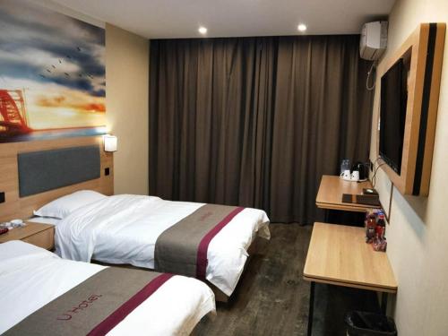 阜阳尚客优酒店安徽阜阳阜南县百货大楼店的酒店客房设有两张床和一台平面电视。